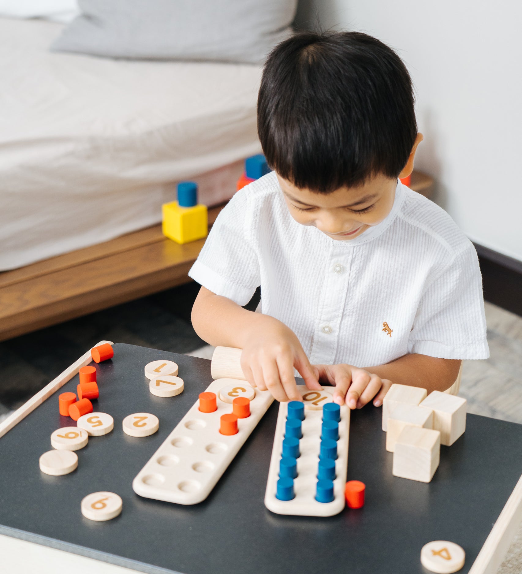 A child playing with the PlanToys 10 Frame Number Game.