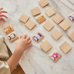 Young boy moving pieces of PlanToys animal blocks guessing game on a white marble table.