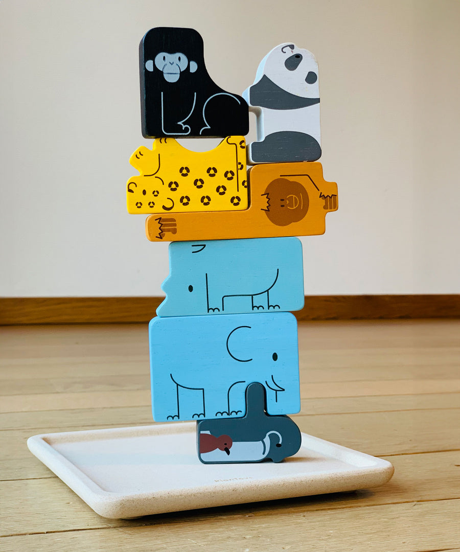 The pieces from the PlanToys Animal Puzzle Game
stacked up on the wooden base that comes with the game.