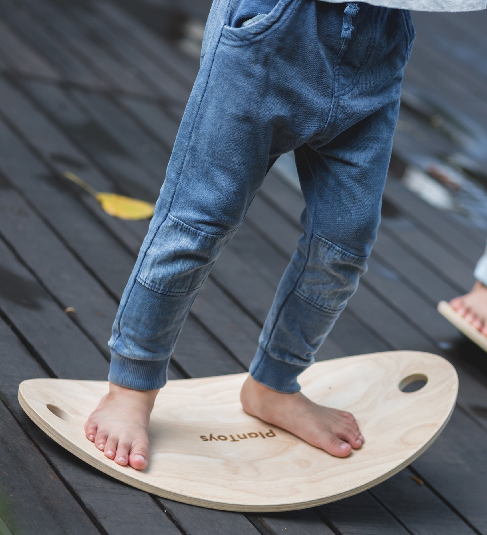 A close up of a child's feet on the PlanToys Balance Board.
