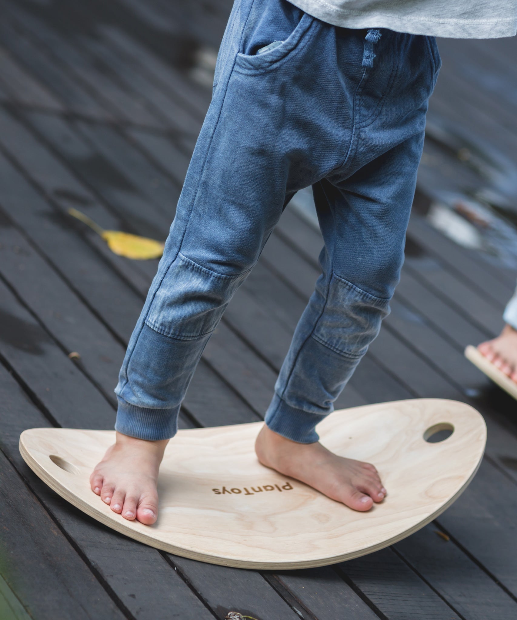 A close up of a child's feet on the PlanToys Balance Board.
