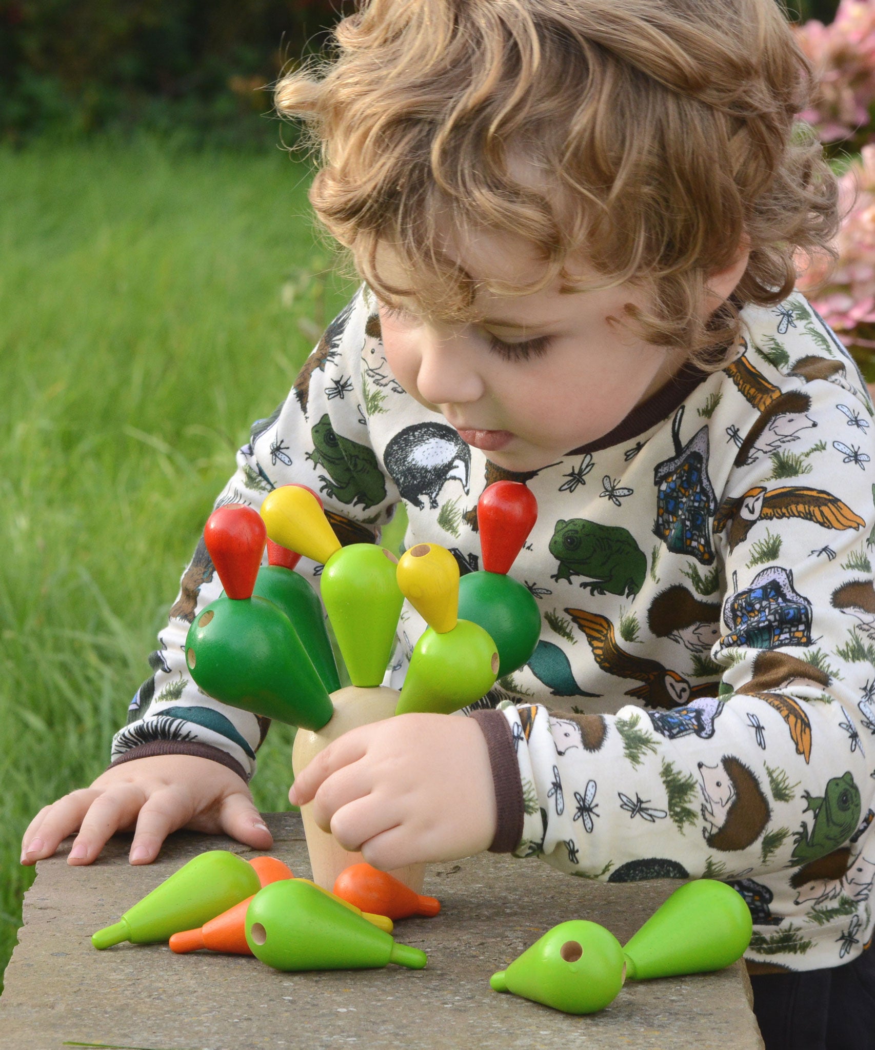 A child playing with the PlanToys Balancing Cactus.