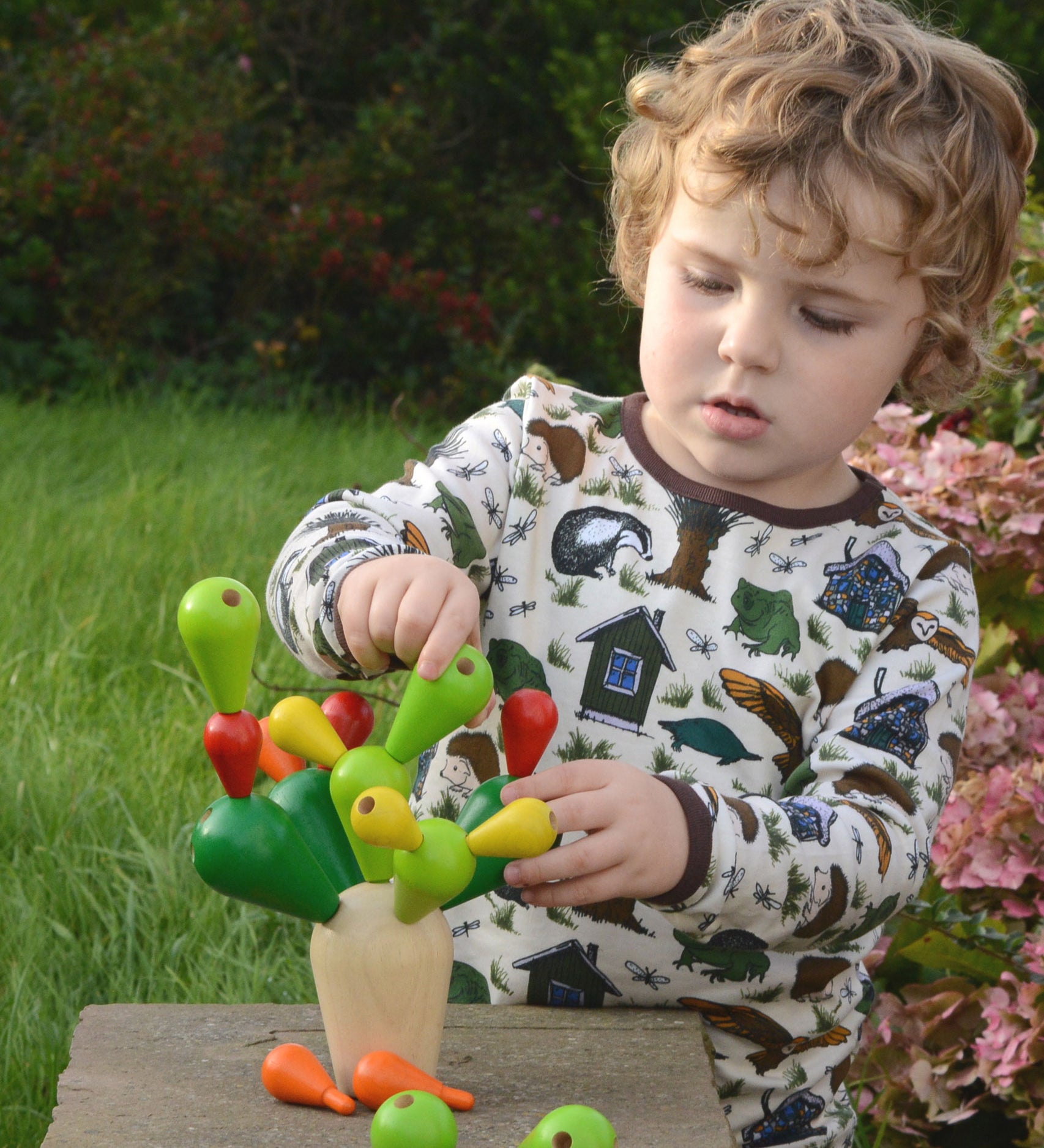 A child playing with the PlanToys Balancing Cactus. 
