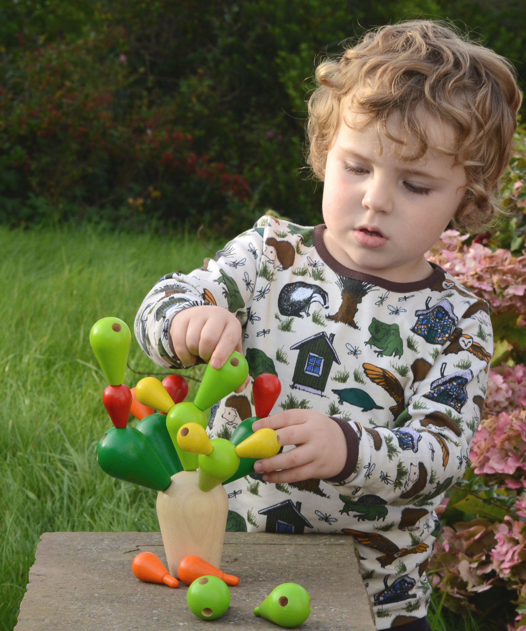 A child playing with the PlanToys Balancing Cactus. 
