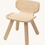 PlanToys wooden child's chair on a plain background.