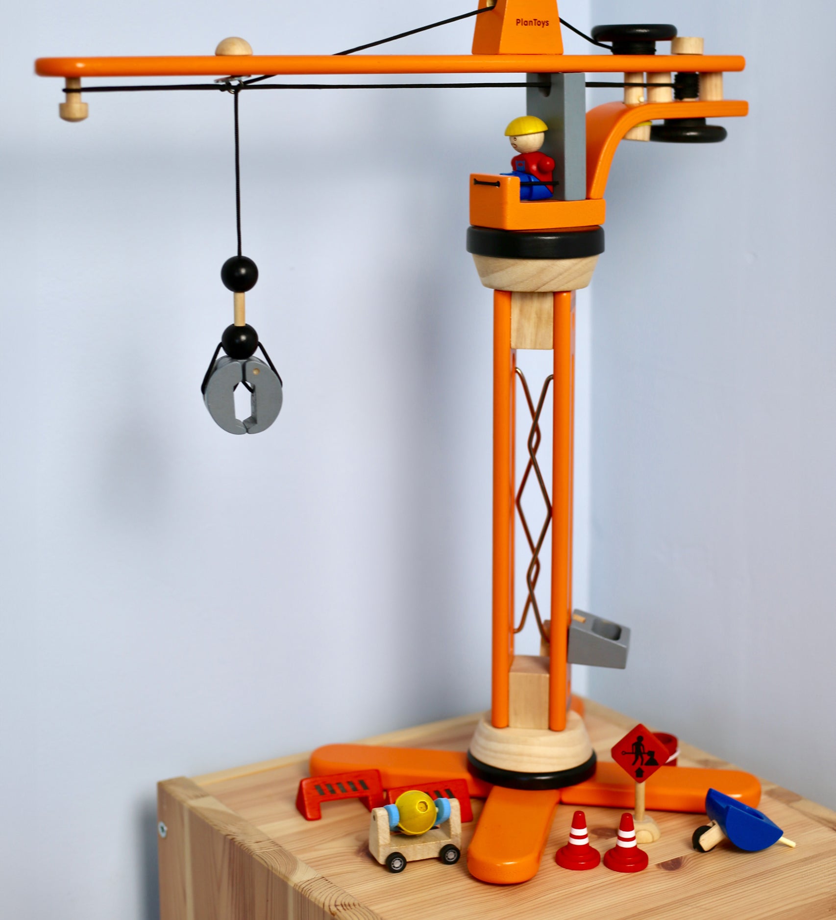 PlanToys PlanWorld Crane Set on a wooden shelf in front of a white wall. 