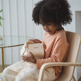 A child sitting down holding the PlanToys Elephant Money Bank.