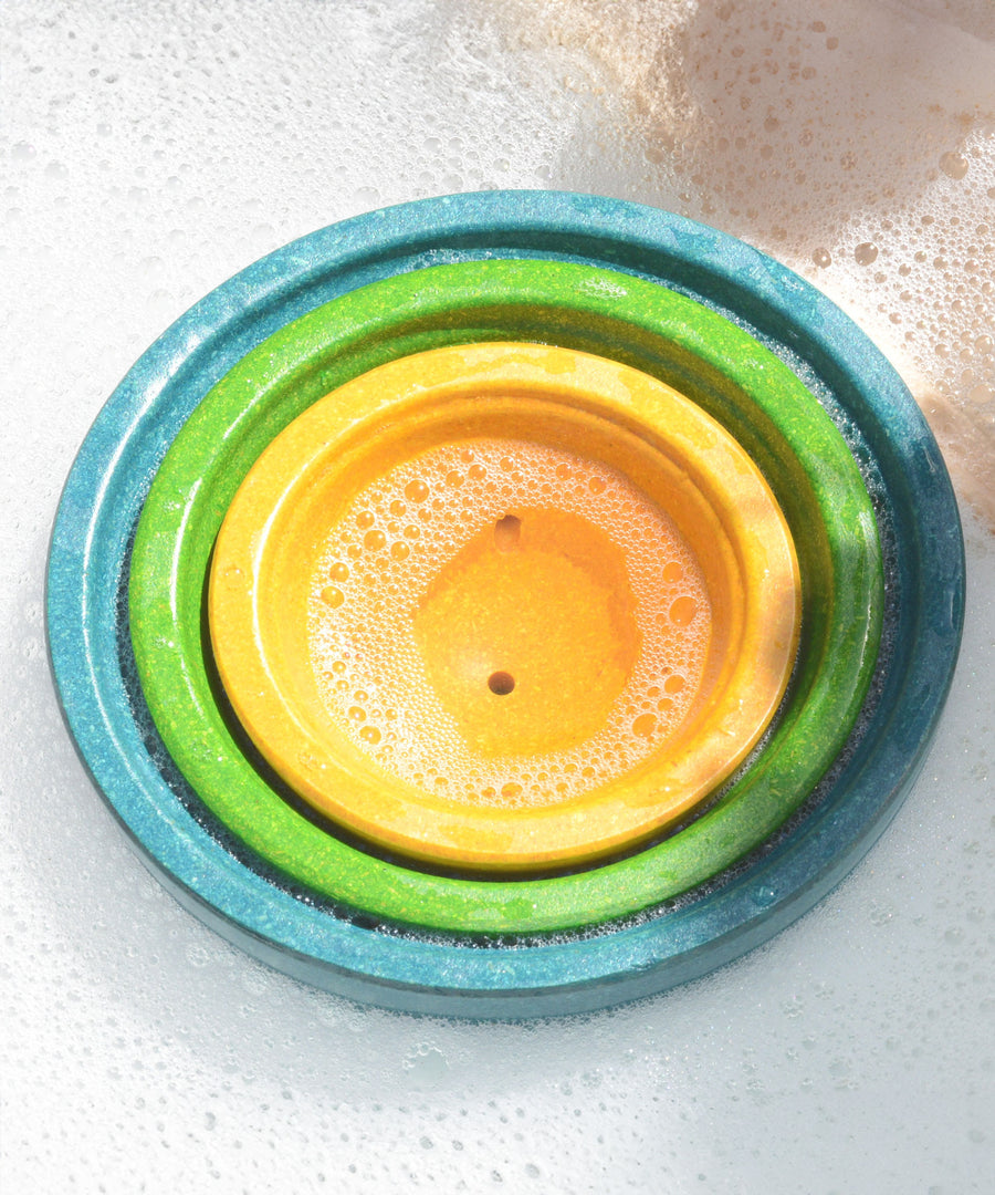 PlanToys Fountain Bowl Set nestled inside each other in a tub of bubbly water.