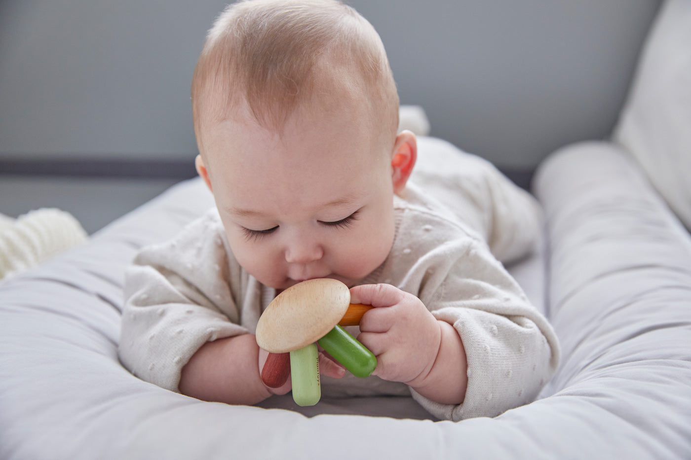 Close up of a baby holding the PlanToys flexi jellyfish baby teething toy close to its mouth