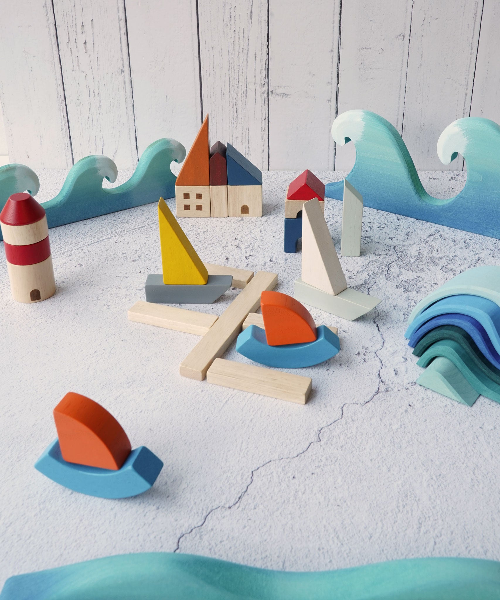 PlanToys Wooden Marina Blocks set up in a small world play set up. The Bumbu waves and the Grimm's small waves can be seen in the background. 