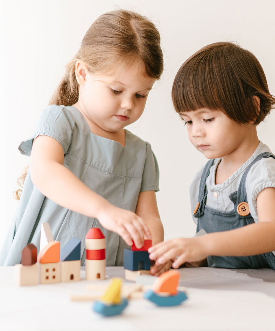 Two children playing with the PlanToys Wooden Marina Blocks, 