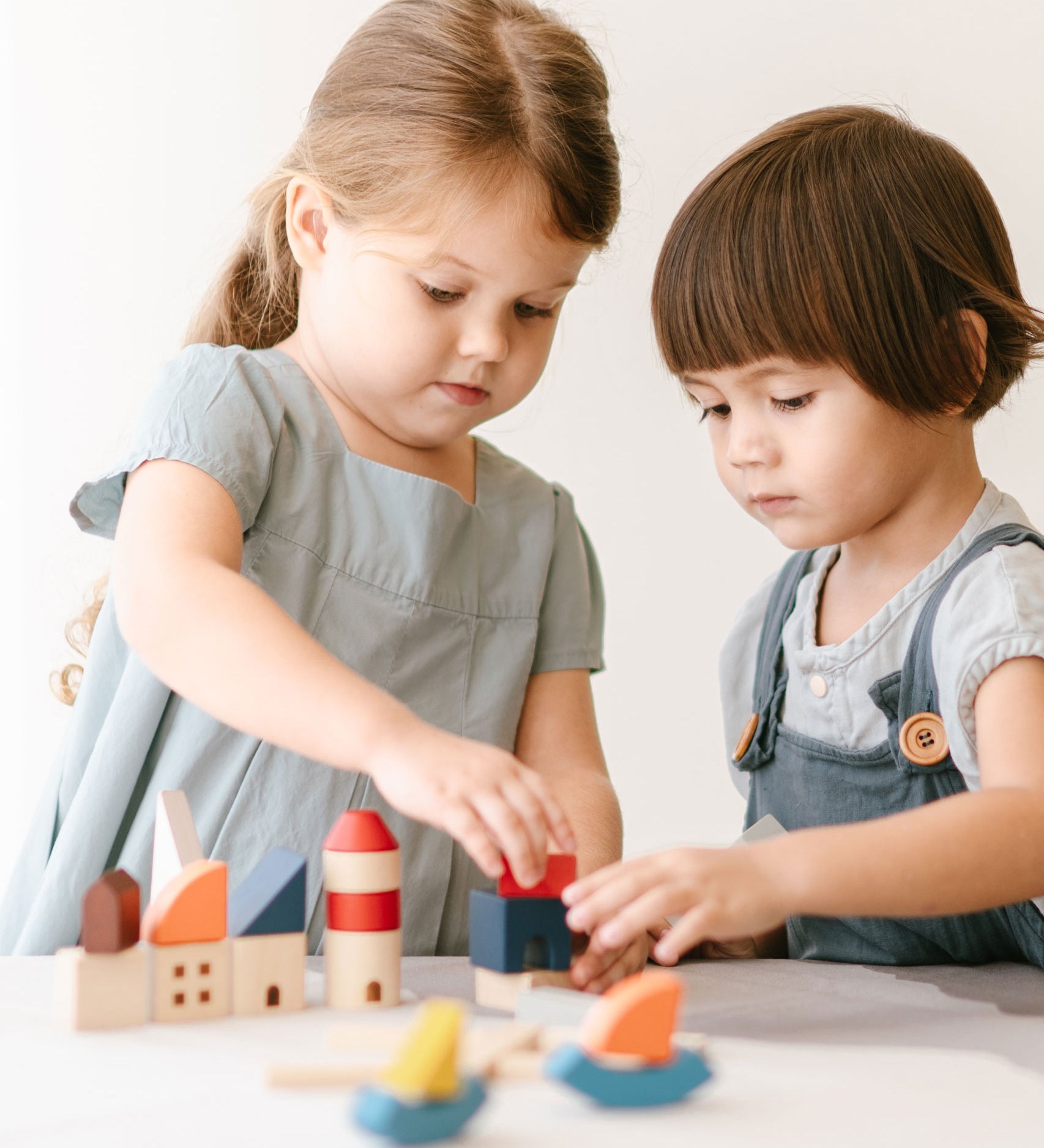 Two children playing with the PlanToys Wooden Marina Blocks, 