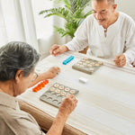 2 people sat at a table playing with the PlanToys wooden bingo board game