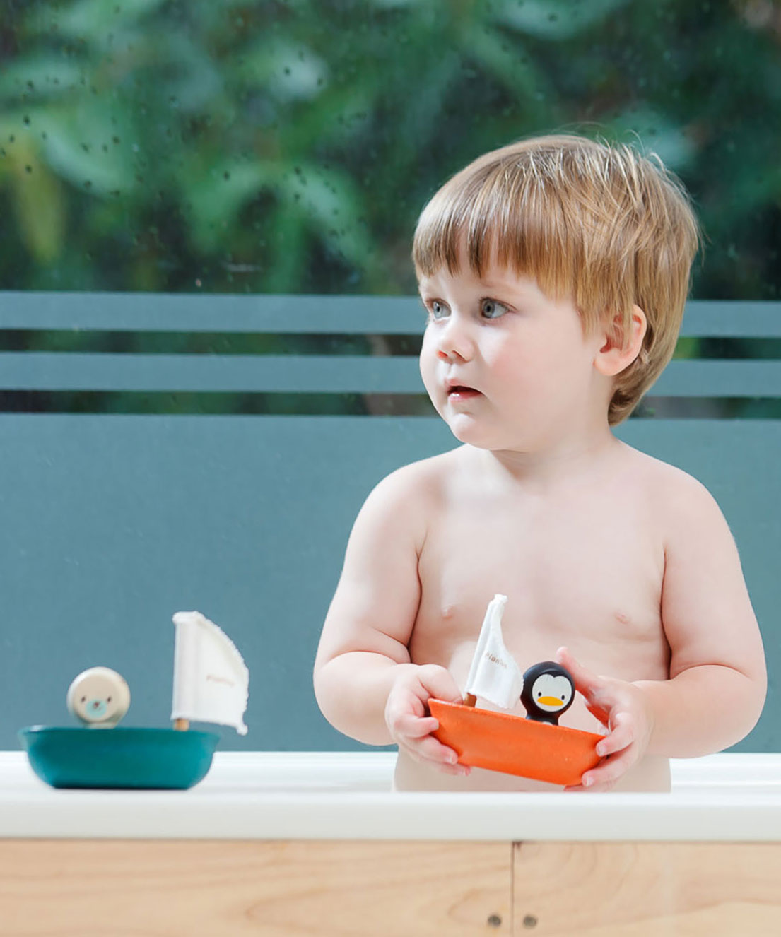 Plan Toys Penguin Sailing Boat being played with. 