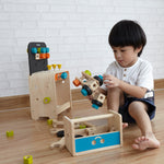 A child playing with PlanToys wooden construction toys. 