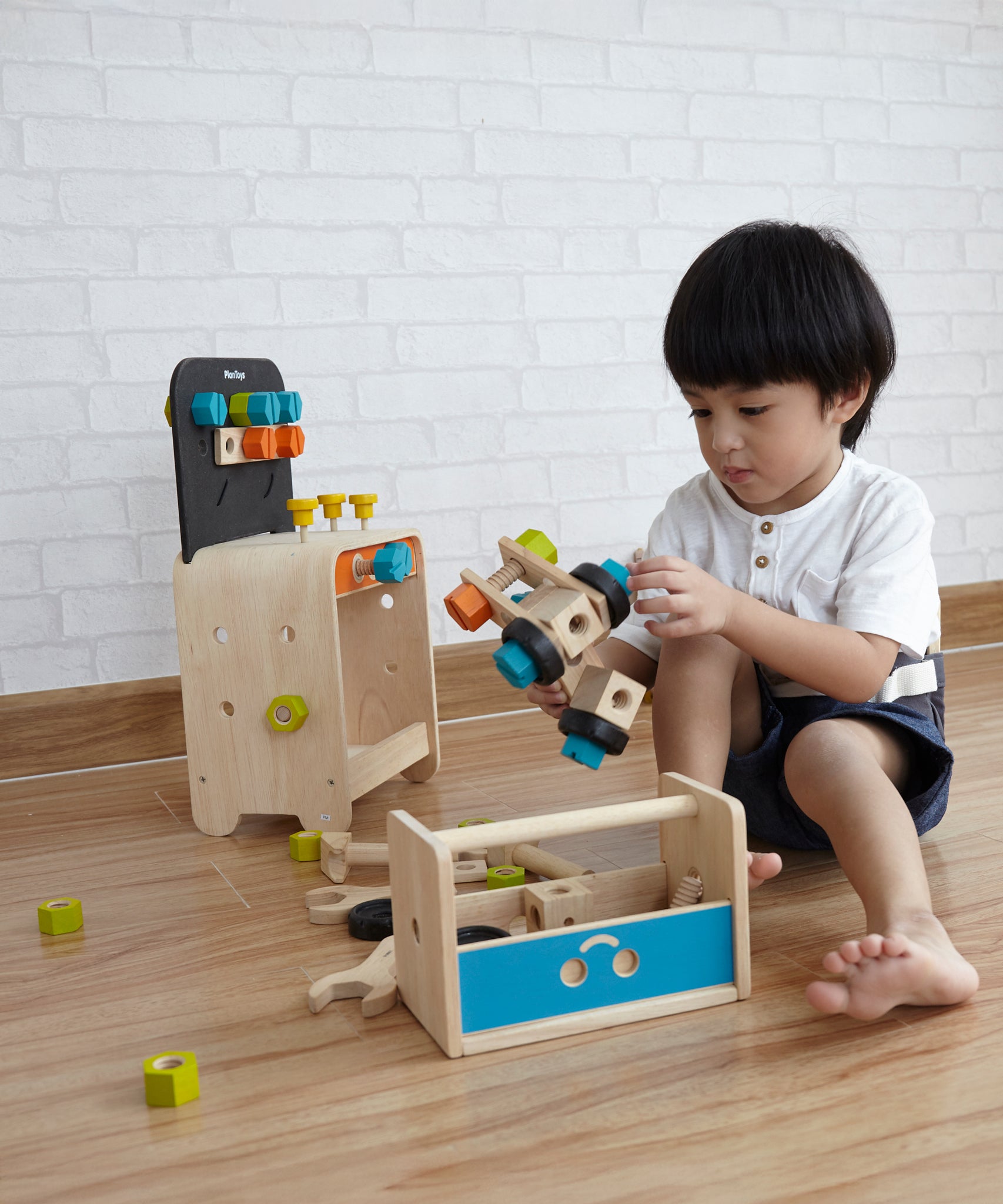 A child playing with PlanToys wooden construction toys. 