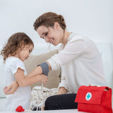 A child and adult playing with the PlanToys Doctor Set. The child is using the blood pressure cuff on the adult. 