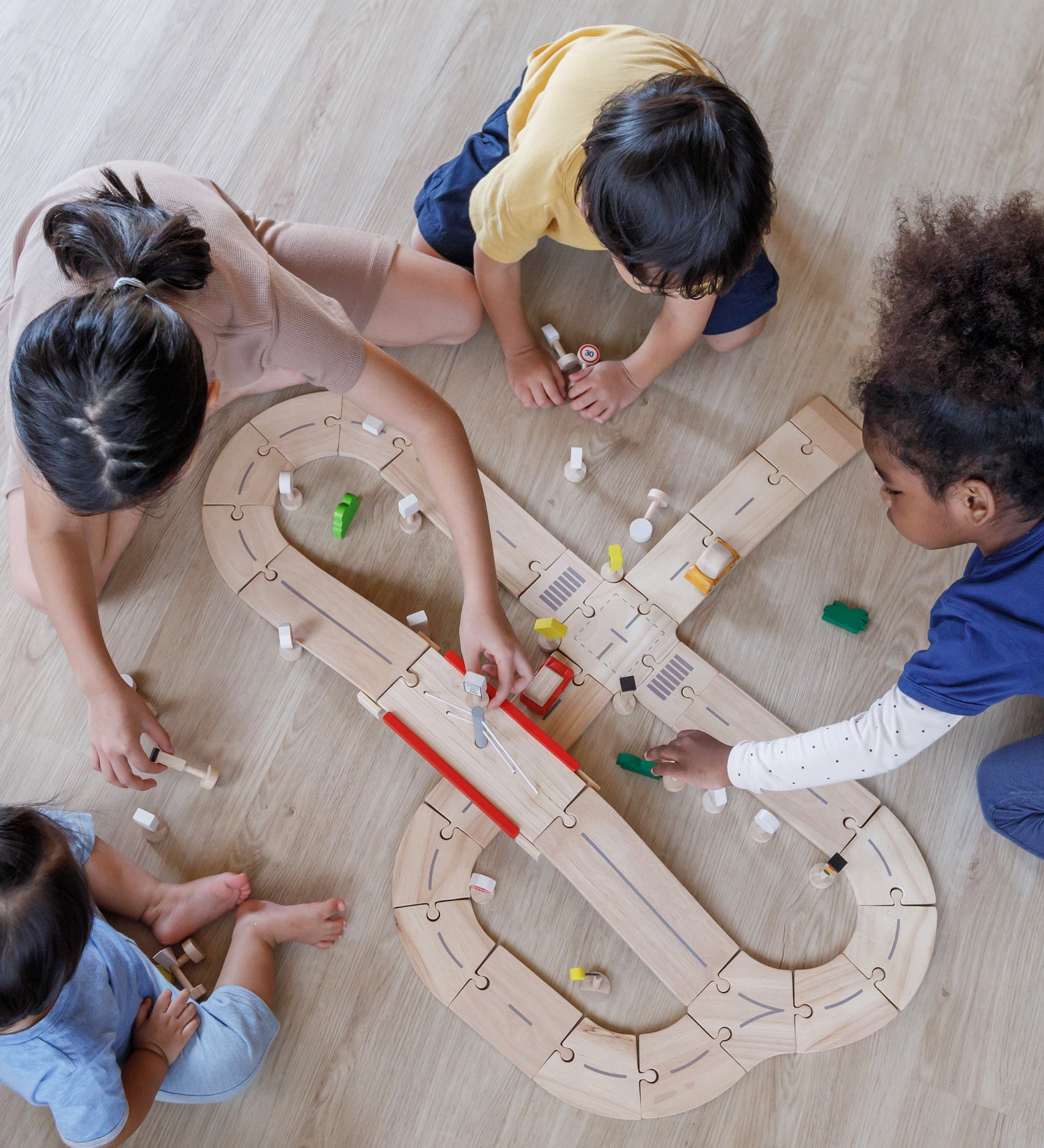 An overhead view of children playing with the PlanToys Road System.