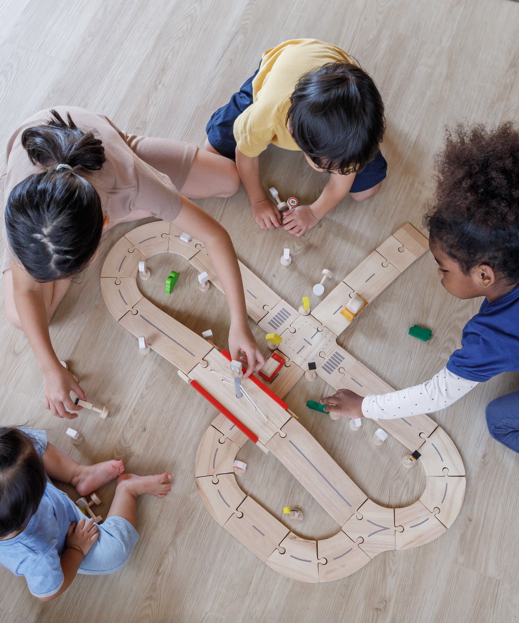 An overhead view of children playing with the PlanToys Road System.