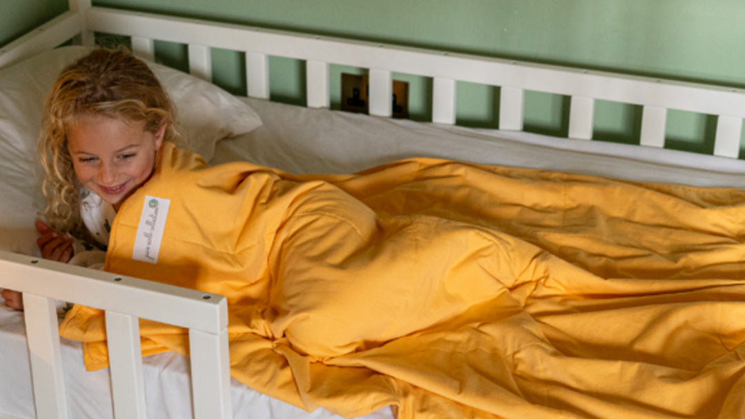 Toddler sleeping with a yellow Pure Earth Collection blanket