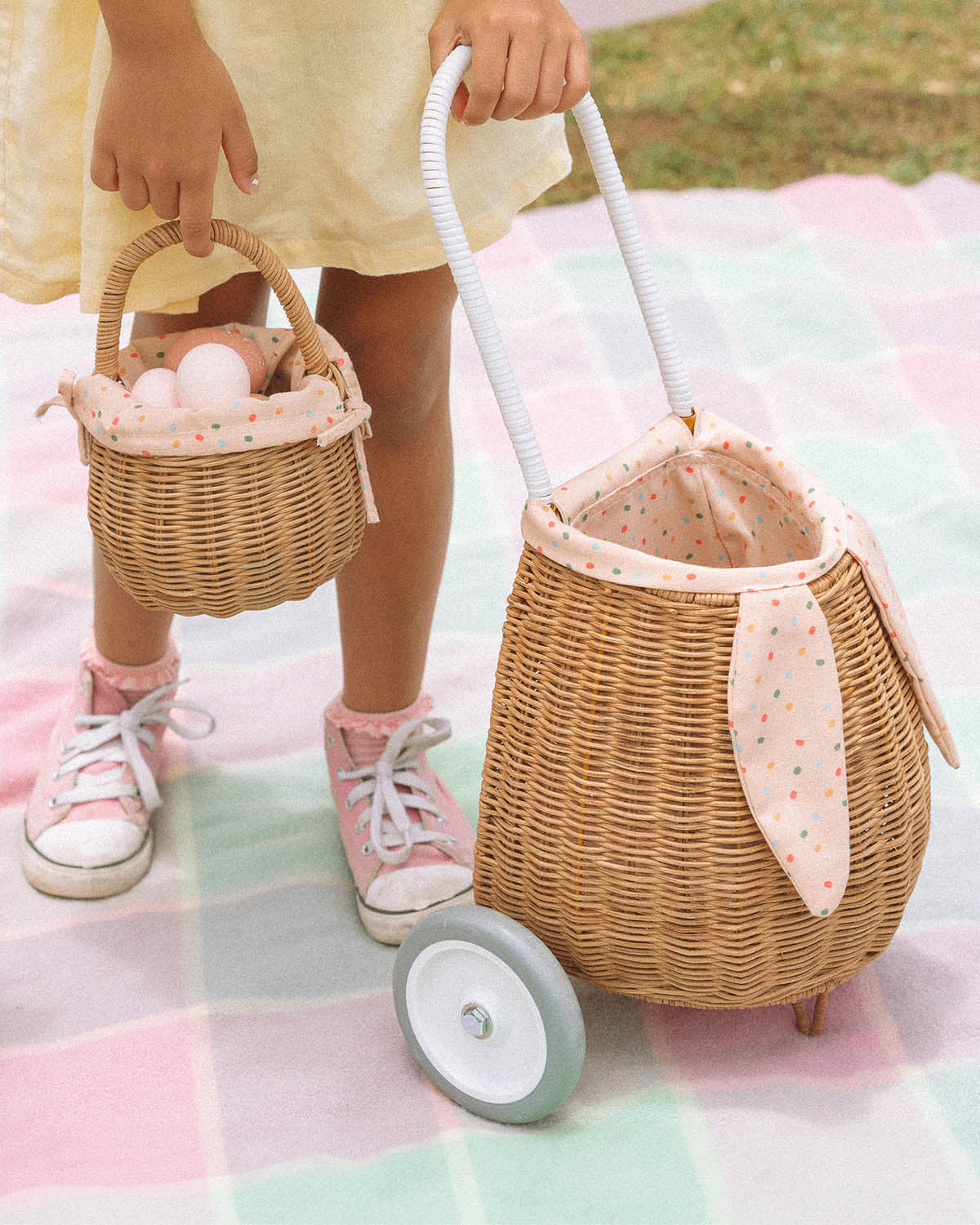 A view from the the back of the Olli Ella Rattan Bunny Luggy with Lining – Pansy Floral. A beautifully woven pull along Luggy basket with cream cotton lining with a vintage pansy floral pattern with bunny ears and a white fluffy tail