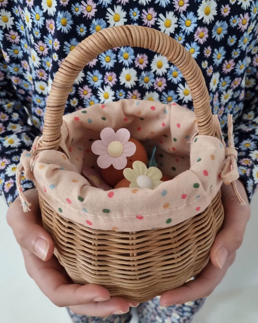 A child sat on a colourful basket