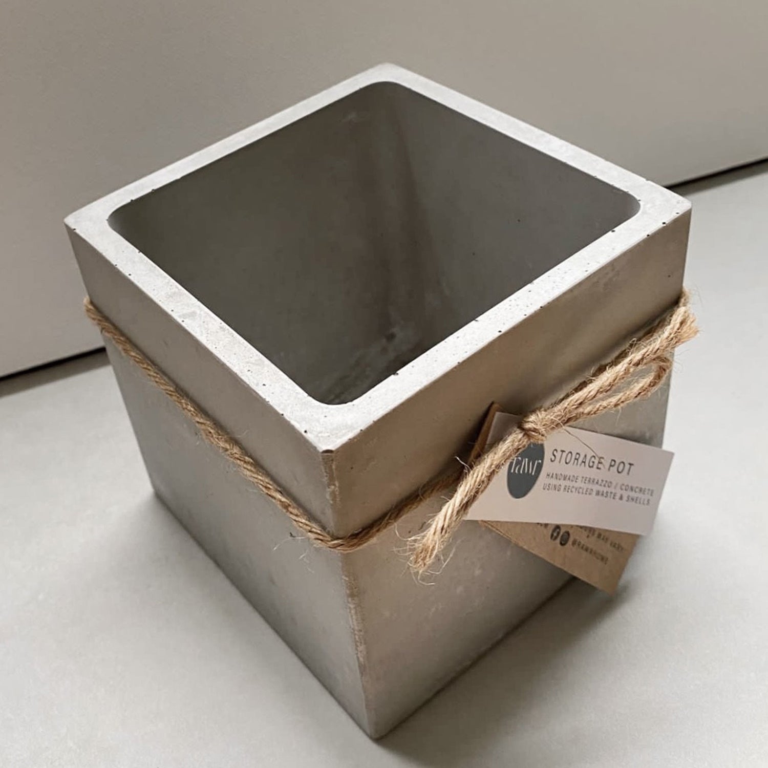 An empty Rawr Grey Concrete Square Storage Pot sits on a concrete worktop.