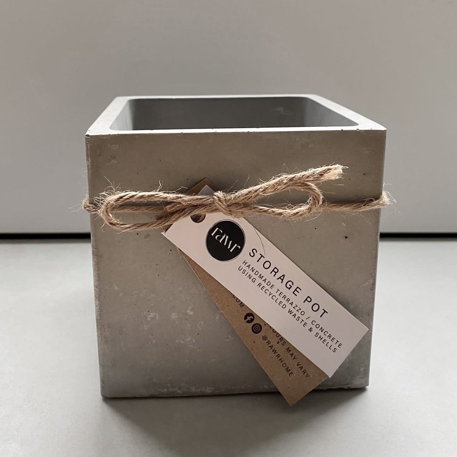 An empty Rawr Grey Concrete Square Storage Pot sits on a concrete worktop.