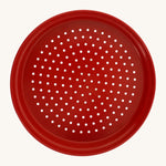 Red metal sand sieve on a cream background