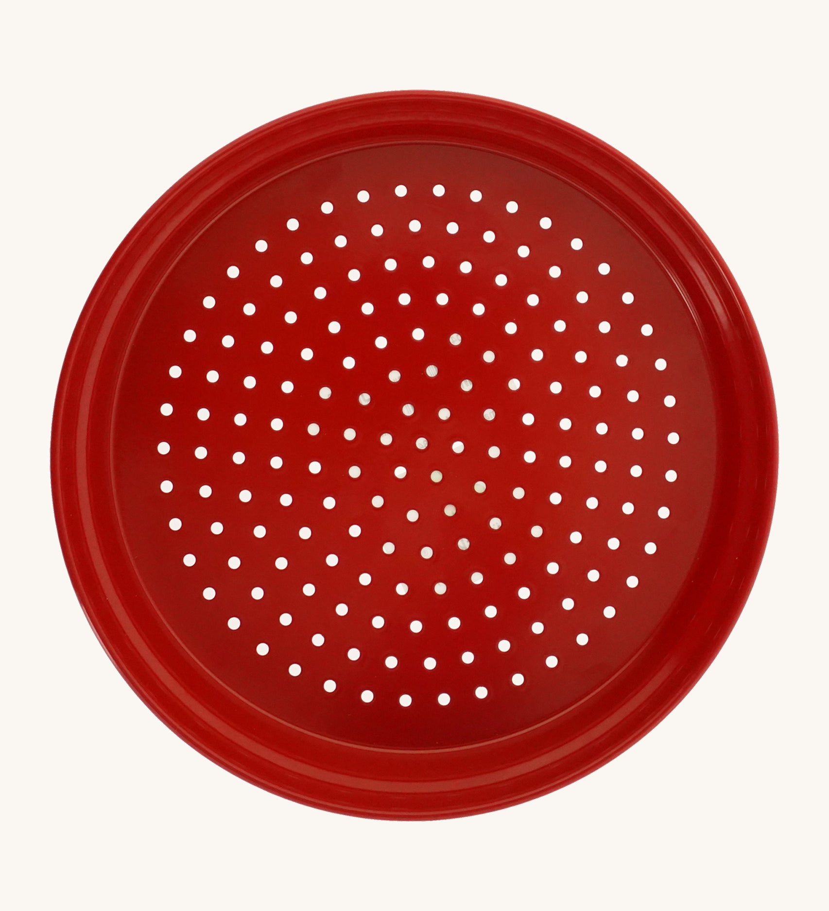 Red metal sand sieve on a cream background