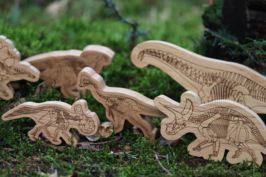 Reel wood handmade wooden dinosaurs stood up on some moss