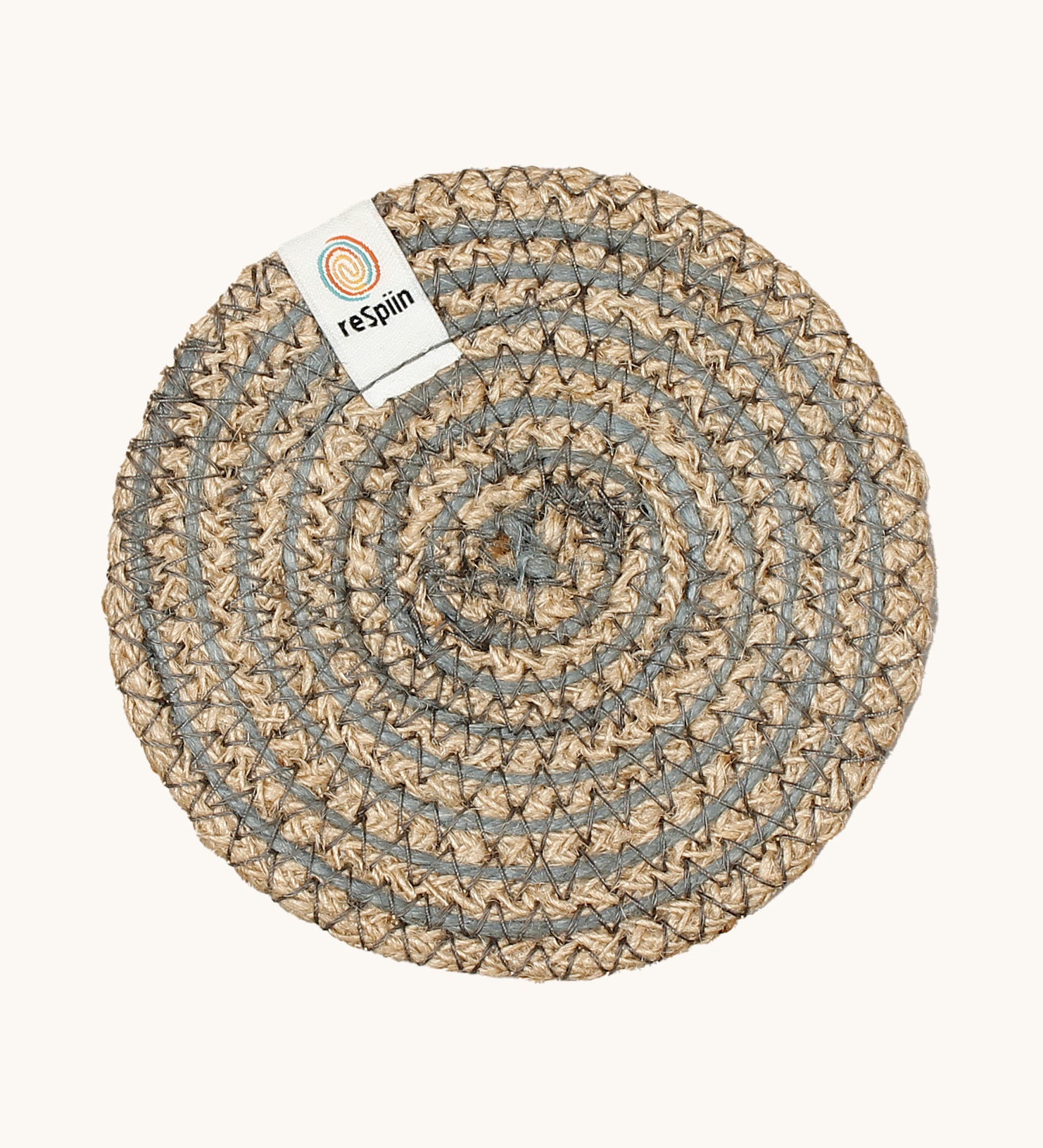 Respiin natural jute coaster in grey spiral on a cream background