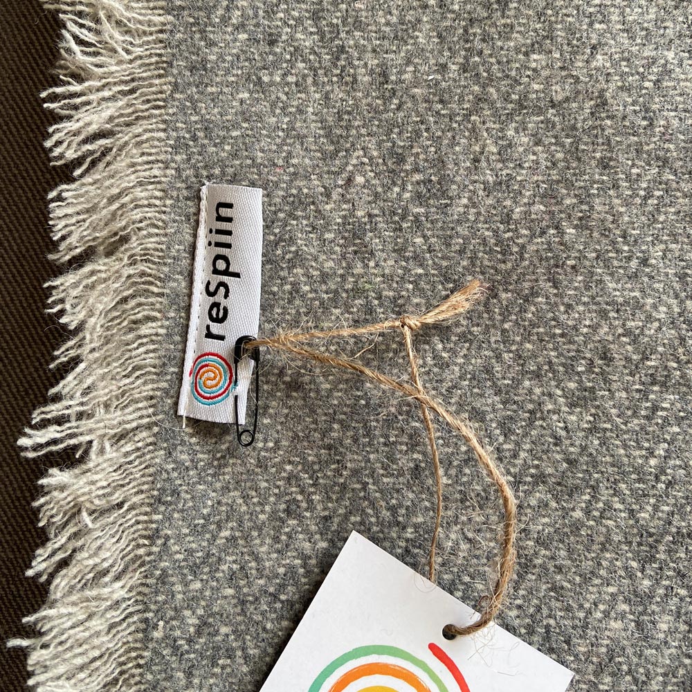 Close up of the Respiin logo on the large grey wool throw