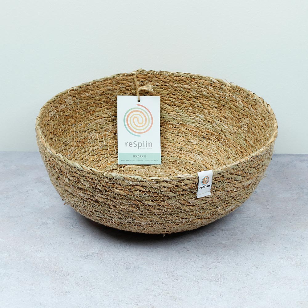 ReSpiin Seagrass Natural large woven Bowl with respiin white label and products label inside bowl on a grey surface on an off-white background