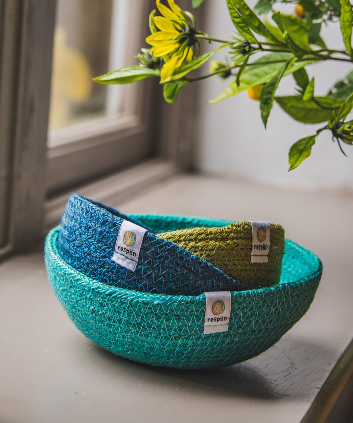 ReSpiin Jute Multicoloured Mini Bowl Set of 3 in the ocean colourway nestled inside each other placed on a window sill