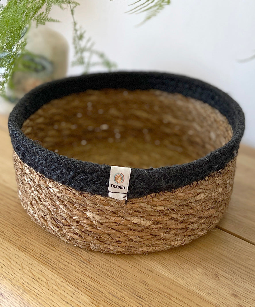 Respiin shallow basket in natural just and black on a mantle piece