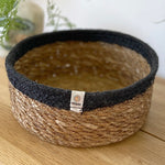 Respiin shallow basket in natural just and black on a mantle piece