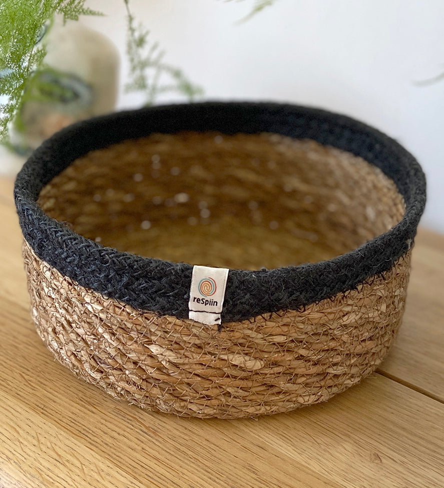 Respiin shallow basket in natural just and black on a mantle piece