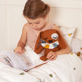 A child holding the Roommate Duke The Dog Canvas Doll whilst reading in bed. 