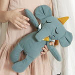 A close up of a child holding onto a Roommate Eddy The Elephant Canvas Doll.