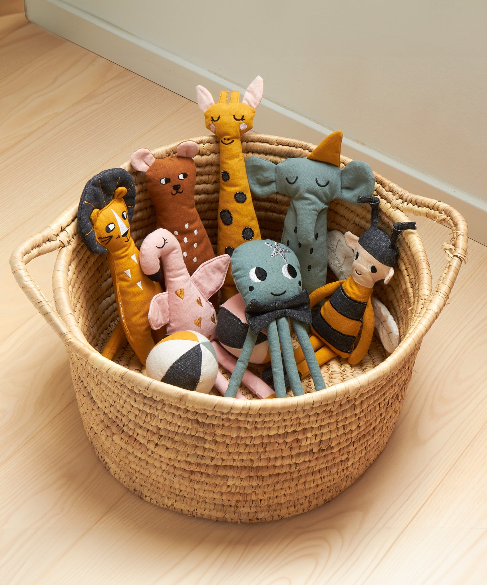 A collection of Roommate cotton ag dolls in a seagrass basket. 