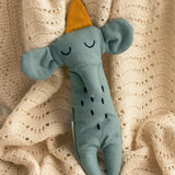 A Roommate Elephant Rag Doll on a cream coloured knitted blanket. 