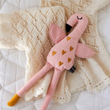 A Roommate Flamingo Rag Doll placed on a cream coloured knitted cardigan.