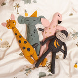 Four Roommate Rag Dolls on a patterned duvet cover, giraffe, elephant, flamingo and monkey.  