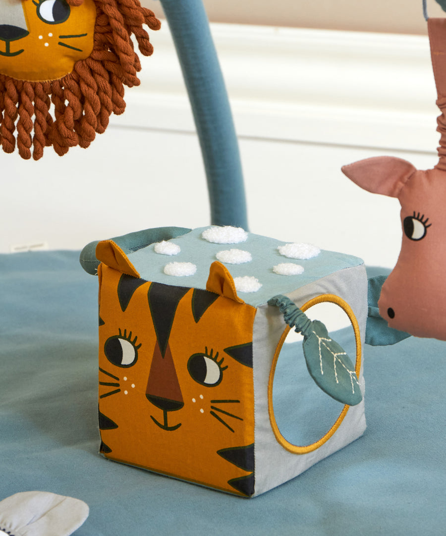 The Roommate Jungle animals soft Baby Activity Cube toy showing the side with the tiger face and the side with the mirror.