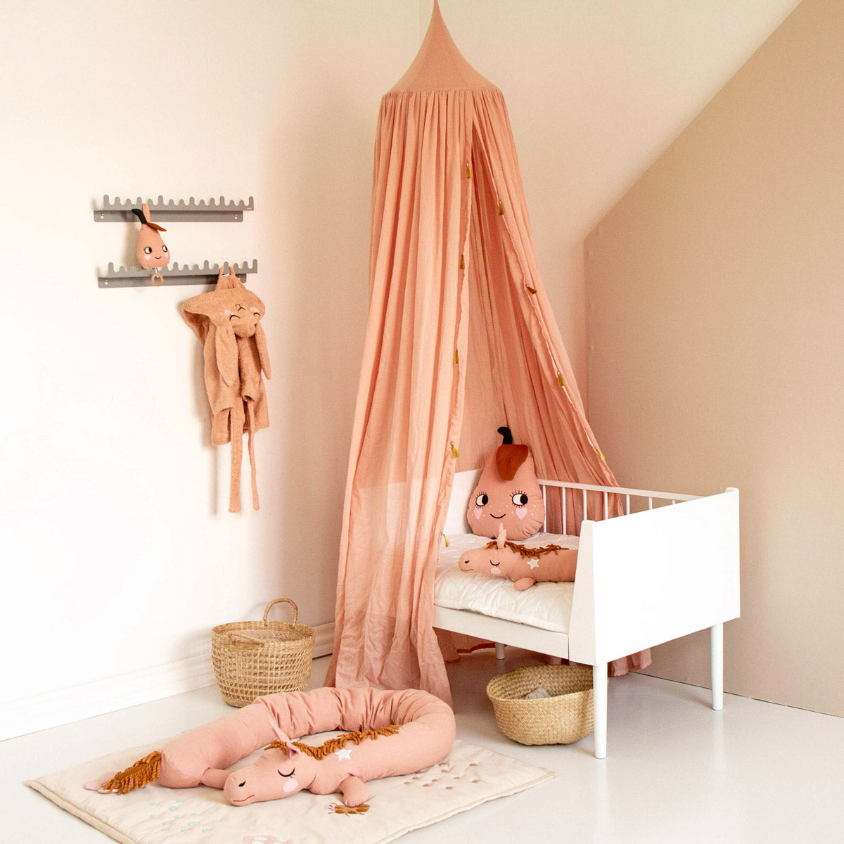 Roommate pink organic cotton canopy tent hanging over a children's bed in a pink and white bedroom