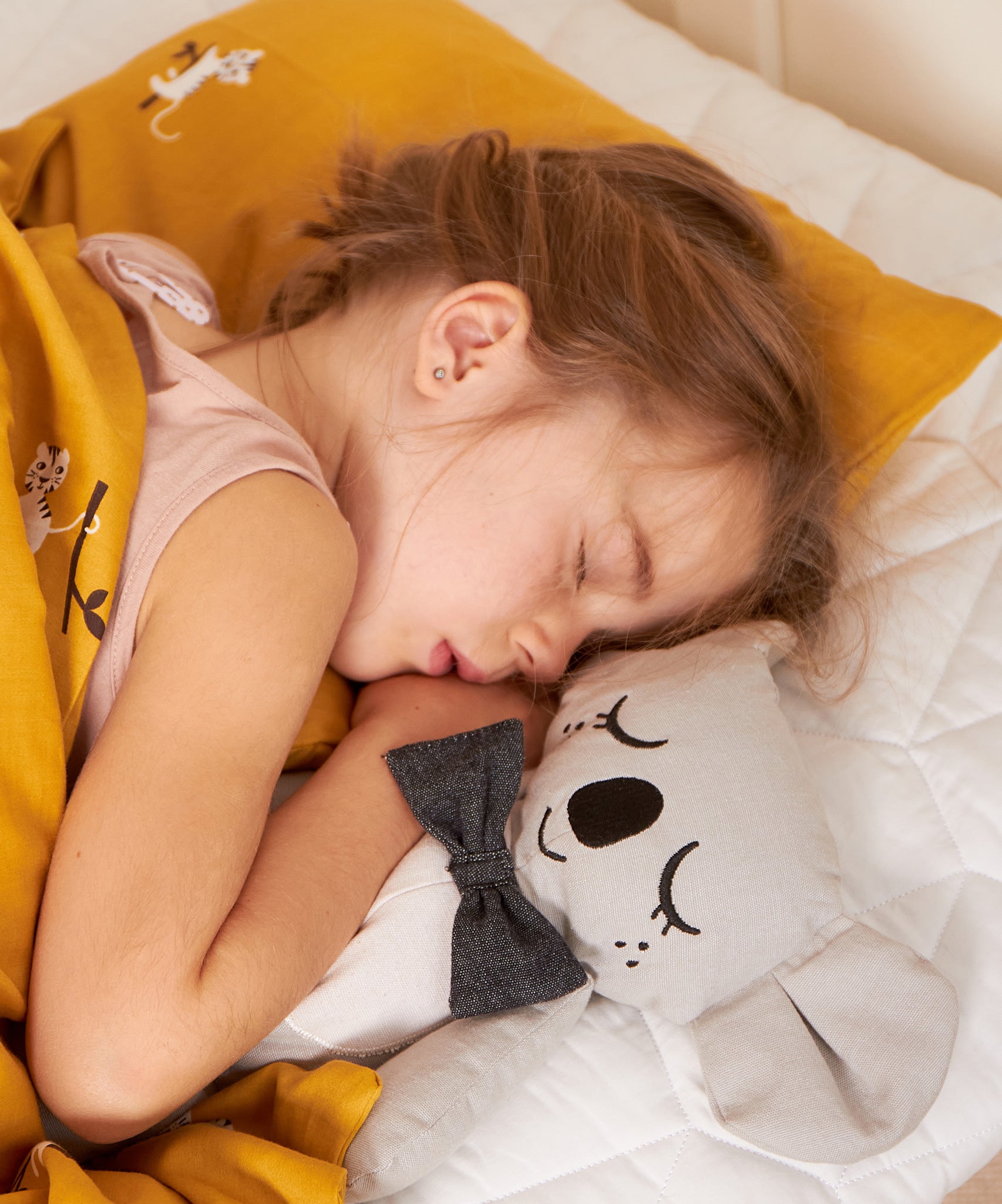 A child sleeping next to a Kody The Koala canvas doll.