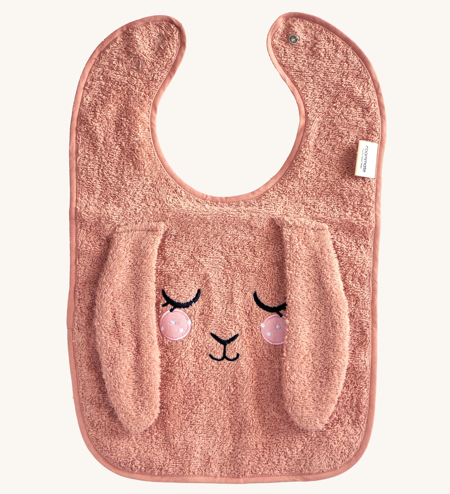 Roommate Baby Bib - Bunny in a soft, pale pink fabric, with a sleepy embroidered face and soft, floppy ears