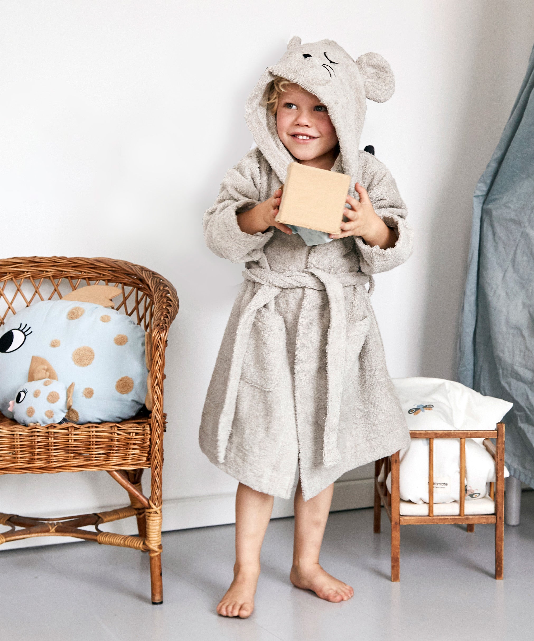 A child wearing the Roommate organic cotton bathrobe with a mouse design. 