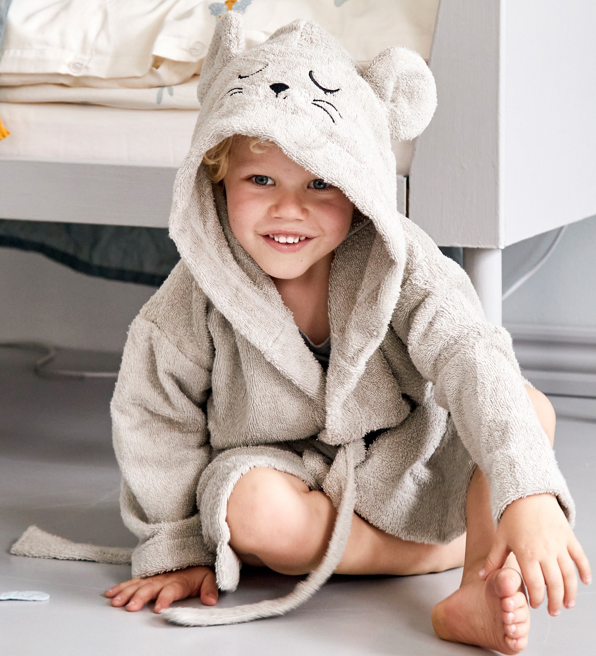 A child wearing the Roommate mouse bathrobe in a bedroom. 